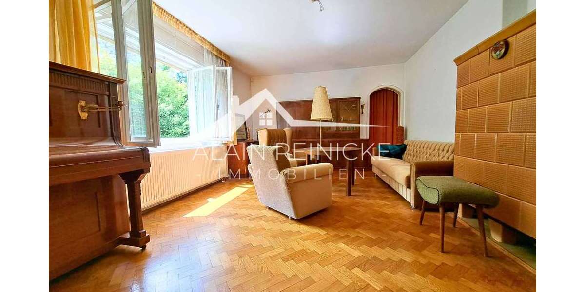 Wohnzimmer mit großen Fenstern und Kamin